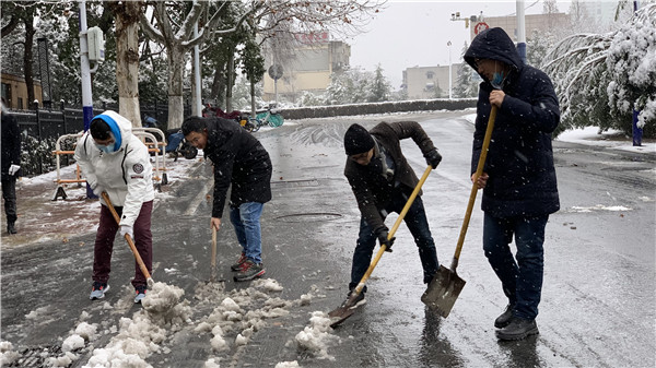 图一党员干部清除车辆出入口积雪.jpg