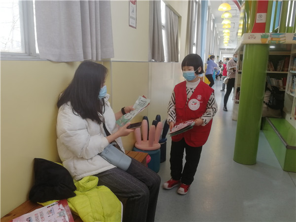 图一  小志愿者给读者分发文明宣传单.jpg