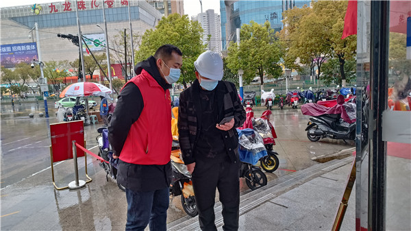图一 党员薛帅指导居民扫码登记.jpg
