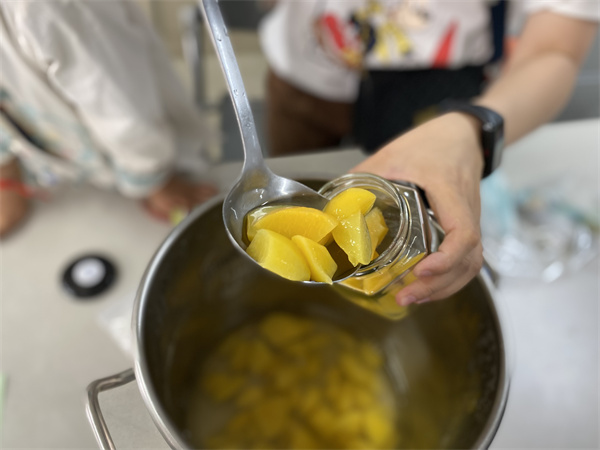 图二 家长与孩子一起制作黄桃罐头.jpg