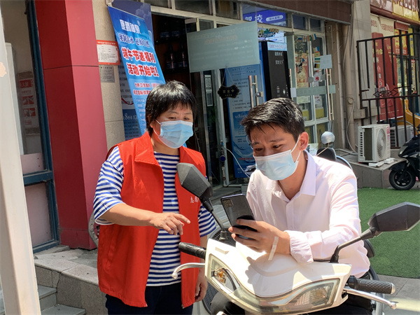图一 周莉同志在引导居民扫码.jpg