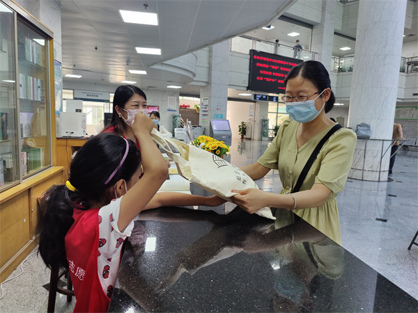 图二“小合苗”家长接过爱心大礼包.jpg