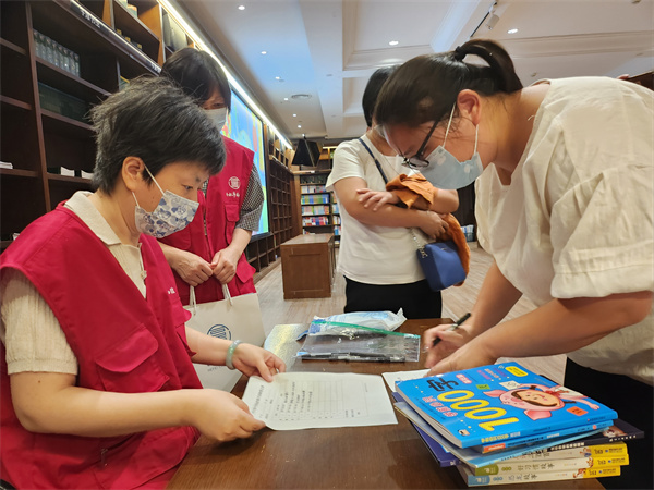 图三志愿者协助登记图书.jpg