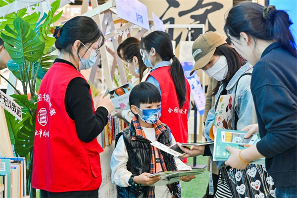 图四 馆员向市民介绍图书馆的“悦读+”服务.png