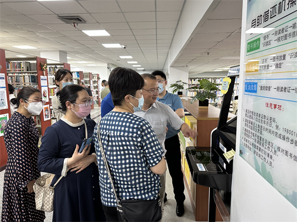 图四 专家同仁们体验全国首台非接触可操作自助借还书机.jpg