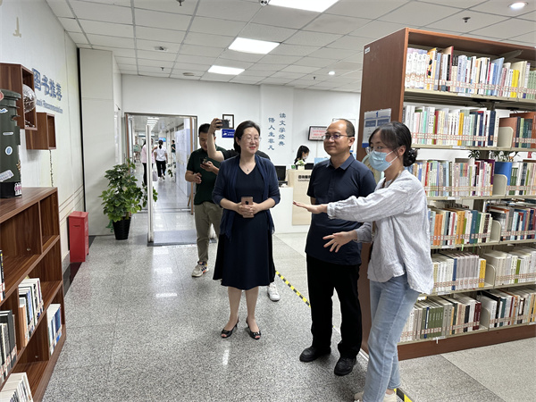 图一 工作人员介绍文学阅览室的新书架.jpg