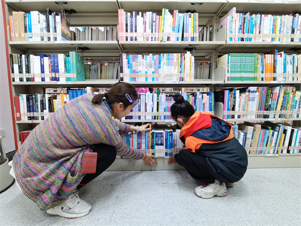 图二 小读者在图书管理员的带领下学习整理书架.jpg