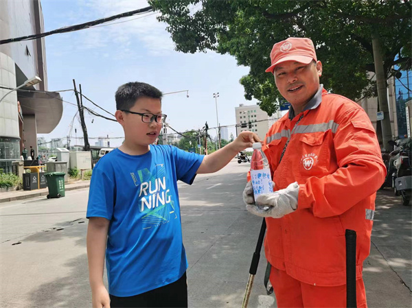 图四 孩子们给环卫工送上矿泉水.jpg