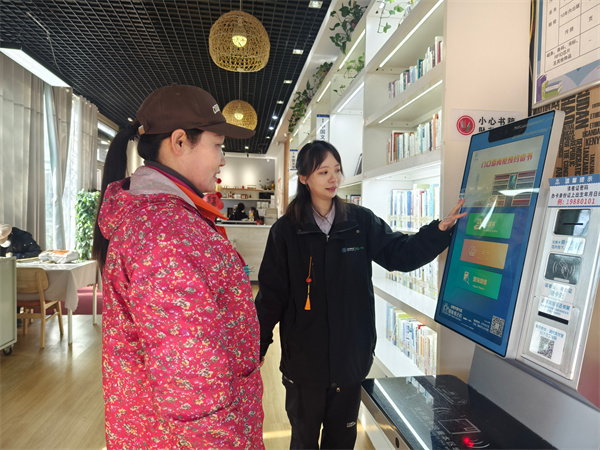 图一 工作人员给户外劳动者介绍自助借还书机的使用方法.jpg