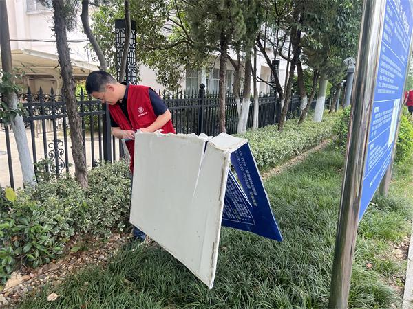 图五 党员干部们走进绿化带深处清理垃圾.jpg