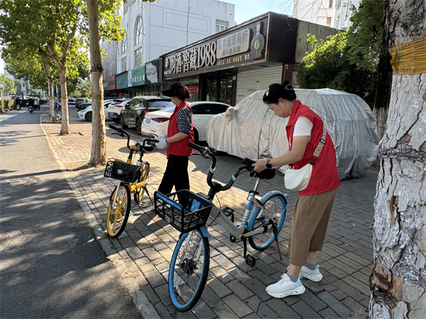 图四 党员志愿者们摆放共享自行车.jpg