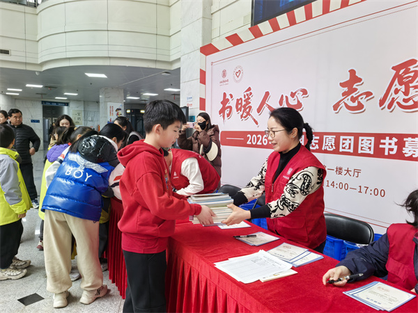 图一 学生将自己的书交给志愿者.jpg 图一 学生将自己的书交给志愿者.jpg