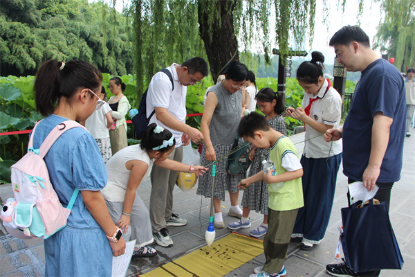 图一 大家用毛笔蘸清水协作书写“清”字.jpg 图一 大家用毛笔蘸清水协作书写“清”字.jpg