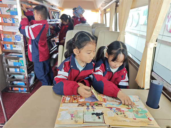 图七 “车轮上的科普大课堂”项目中孩子们在流动图书车内选择科普图书进行阅读.jpg 图七 “车轮上的科普大课堂”项目中孩子们在流动图书车内选择科普图书进行阅读.jpg